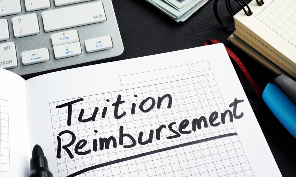 Tuition reimbursement written on a page of notepad.